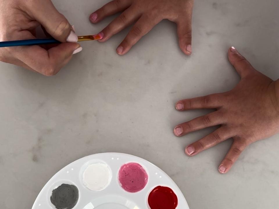 Mom painting kid's nails with Elmer's glue nail polish