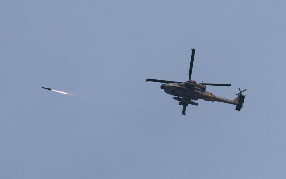 An Israeli military Apache helicopter fires a missile near Israel-Gaza border, amid the ongoing conflict between Israel and the Palestinian Islamist group Hamas, as seen from southern Israel, December 23, 2023.
