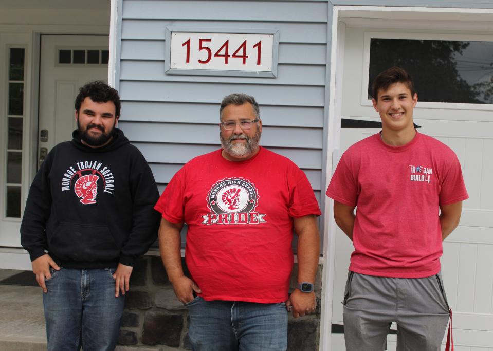 Standing in front of Trojan Build 4 are Monroe High School junior Dan Kittle, left, Construction Trades instructor Tom Bell and MHS junior Adam Nabozny. Kittle and Nabozny were two of the 43 students who worked on the house's construction.