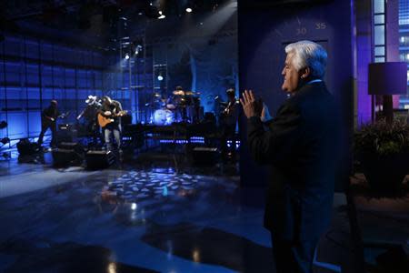 Jay Leno applauds singer Garth Brooks on his final night hosting "The Tonight Show with Jay Leno" in Burbank, California in this February 6, 2014 picture provided by NBC. REUTERS/Stacie McChesney/NBC/Handout via Reuters