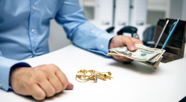 Man buying gold jewellry, pawn shop and us dollar banknotes