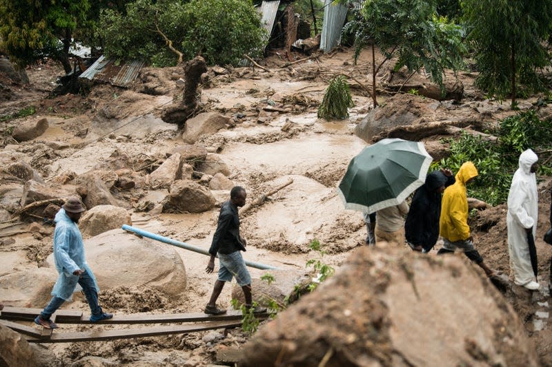 People cross a muddy stretch in Blantyre, Malawi, on March 13.