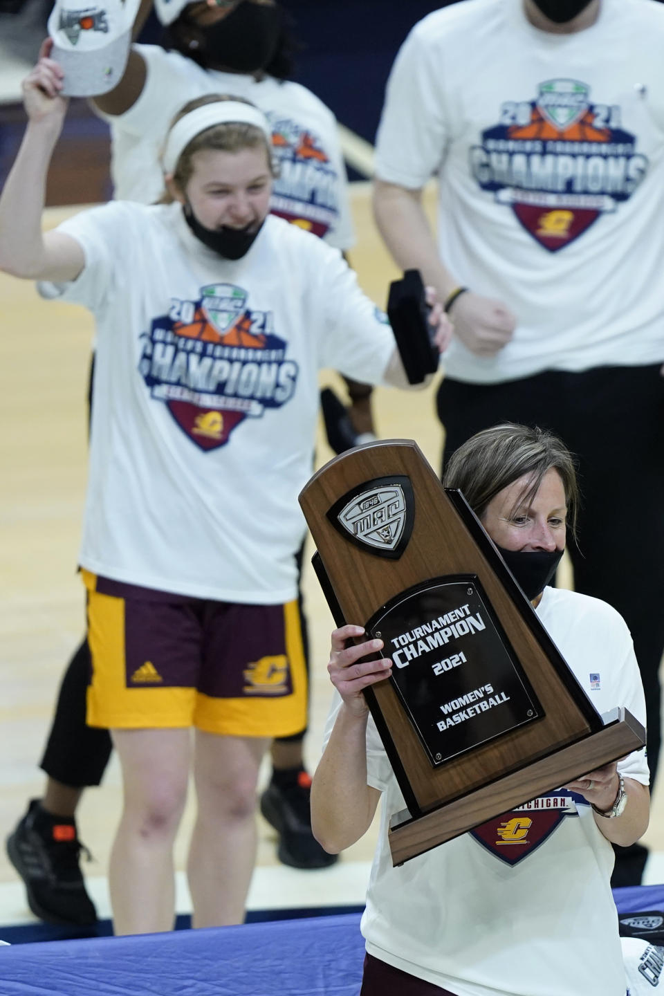 Central Michigan's head coach Heather Oesterle holds up the trophy after Central Michigan defeated Bowling Green 77-72 in an NCAA college basketball game in the championship of the Mid-American Conference tournament, Saturday, March 13, 2021, in Cleveland. (AP Photo/Tony Dejak)