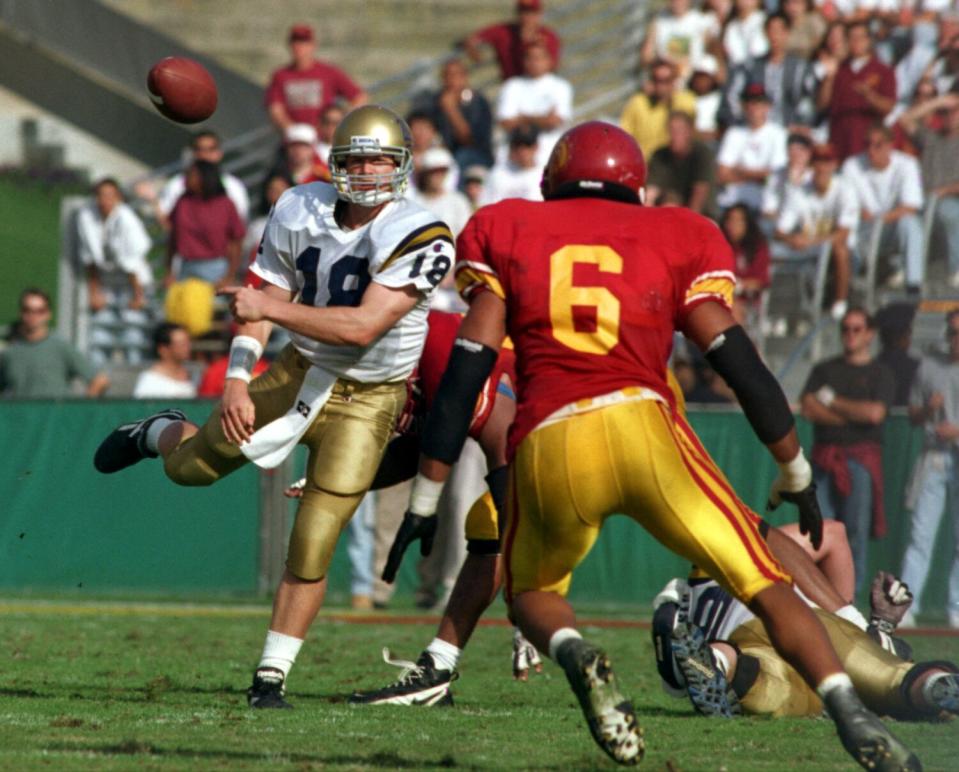 UCLA quarterback Cade McNown gets off a pass despite tight defense in the second quarter against USC's Scott Fields.