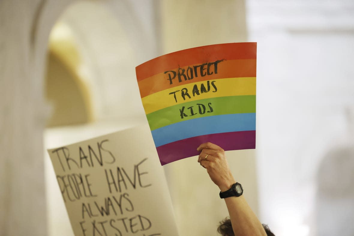 Protestors hold signs during a rally opposing HB2007 at the state capitol in Charleston, West Virginia, on March 9, 2023. HB2007 would ban health care for trans children in the state. (AP Photo/Chris Jackson)