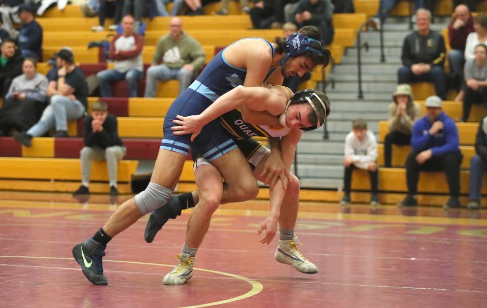 Burrell's Niko Ferra (blue) attempts to bring down Quaker Valley's Michael Carmody (black) during their 139 pound match while competing in the WPIAL 2A Wrestling Team Semifinals Saturday afternoon at Chartiers-Houston High School in Houston, PA.