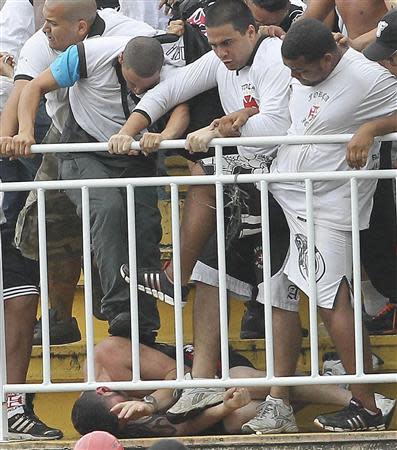 Vasco da Gama soccer fans beat up an Atletico Paranaense fan during their Brazilian championship match in Joinville in Santa Catarina state December 8, 2013. REUTERS/Carlos Moraes