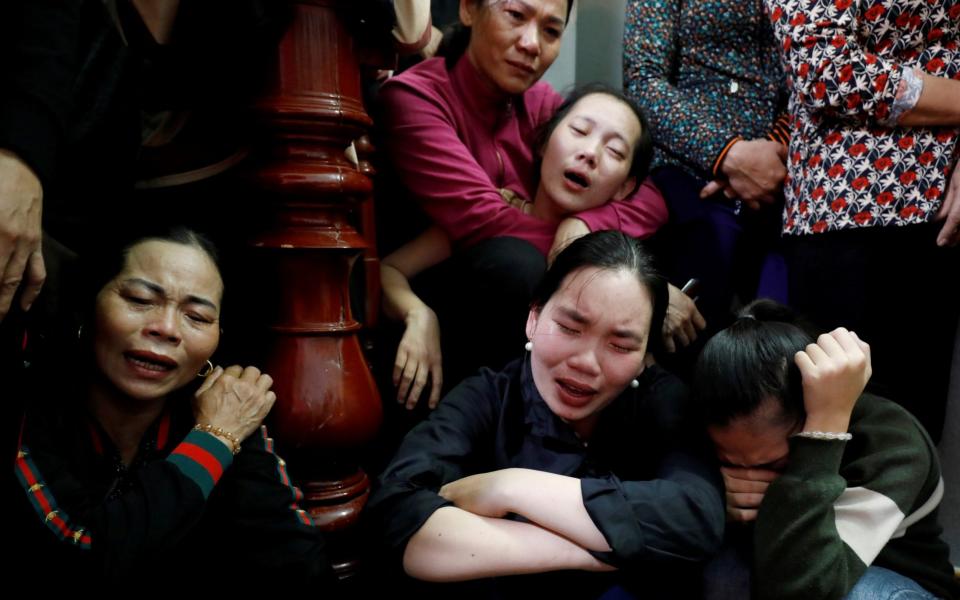 Relatives of John Hoang Van Tiep, a victim, mourn near his coffin during his funeral at home in Nghe An province, Vietnam - REUTERS/Kham