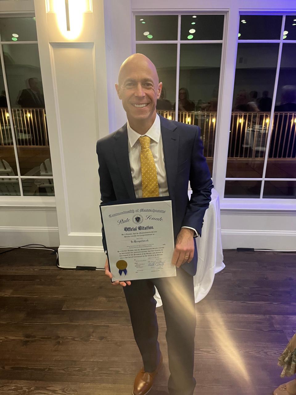 Neil Levine, of Mansfield, a co-owner of Maguire's Bar and Grill in Easton, receives an official citation from state senators for being recognized as School on Wheels' 2023 "Champion for our Kids."