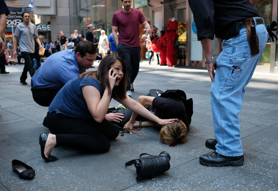 <p>MAY 18, 2017 – People attend to an injured man after a car plunged into him in Times Square in New York.<br> A car plowed into a crowd of pedestrians in New York’s bustling Times Square, leaving one person dead and at least 12 other injured. (Photo: Jewel Samad/AFP/Getty Images) </p>