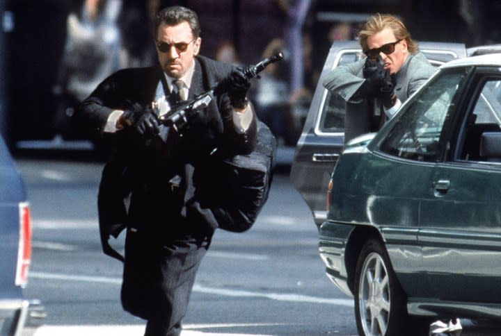 Two men hold guns in a street in Heat.