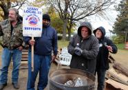 Striking United Auto Workers (UAW) members warm their hands around a burn barrel while picketing outside the General Motors Detroit-Hamtramck Assembly in Hamtramck