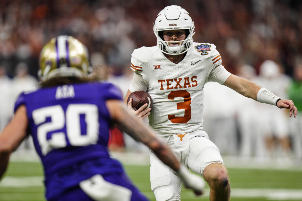 Texas quarterback Quinn Ewers (3) runs near Washington safety Asa Turner (20) during the first half of the Sugar Bowl CFP NCAA semifinal college football game, Monday, Jan. 1, 2024, in New Orleans. (AP Photo/Jacob Kupferman)