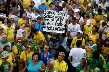 A demonstrator dressed as Batman attends a protest against corruption at the Copacabana beach in Rio de Janeiro, Brazil, December 4, 2016. The sign reads, "We are all Sergio Moro, for a public prosecutor office free and strong. #Get out Renan". REUTERS/Pilar Olivares