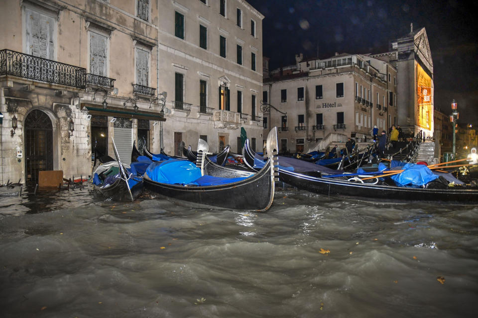 Stranded gondolas float adrift over the flooded banks, in Venice, Wednesday, Nov. 13, 2019. The mayor of Venice is blaming climate change for flooding in the historic canal city that has reached the second-highest levels ever recorded, as another exceptional water level was recorded Wednesday. (AP Photo/Luigi Costantini)