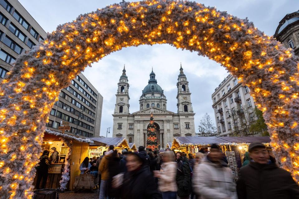 People stroll among stands of a Christmas market in the square in front of St. Stephen Basilica in downtown Budapest, Hungary (EPA)