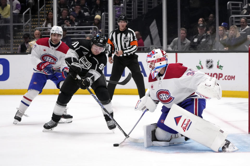Montreal Canadiens goaltender Jake Allen (34), right, stops a shot next to Los Angeles Kings right wing Carl Grundstrom (91) during the second period of an NHL hockey game Saturday, Nov. 25, 2023, in Los Angeles. (AP Photo/Marcio Jose Sanchez)