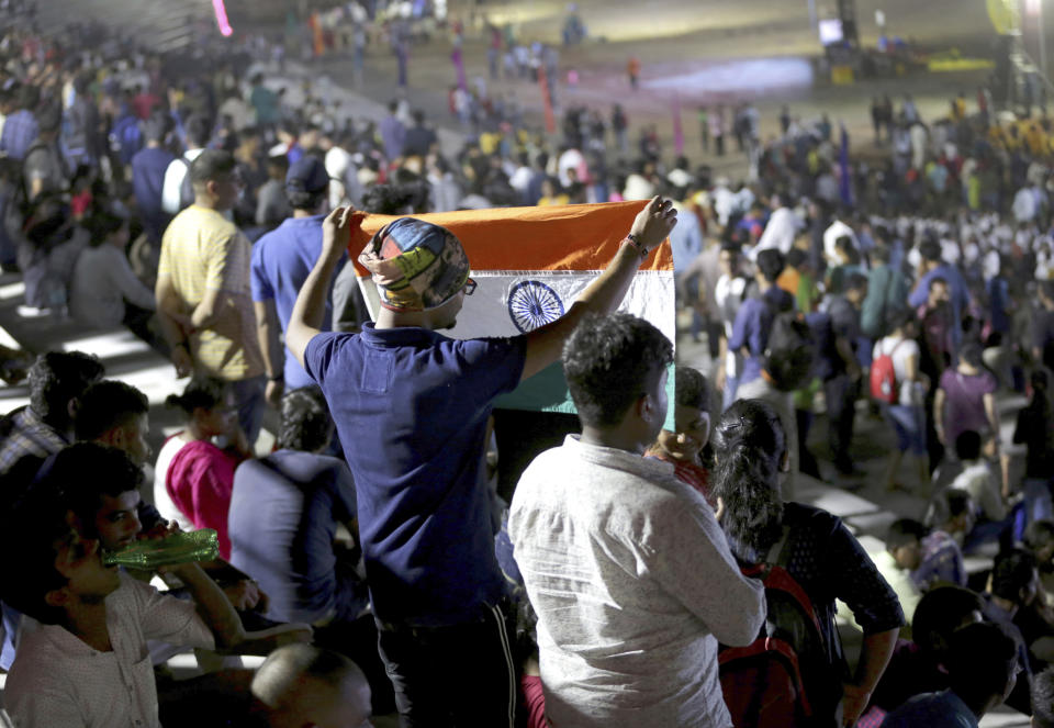 An Indian spectator folds a flag as others leave after the Chandrayaan-2 mission was aborted at Sriharikota, in southern India, Monday, July 15, 2019. India has called off the launch of a moon mission to explore the lunar south pole. The Chandrayaan-2 mission was aborted less than an hour before takeoff on Monday. An Indian Space Research Organization spokesman says a "technical snag" was observed in the 640-ton launch-vehicle system. (AP Photo/Manish Swarup)