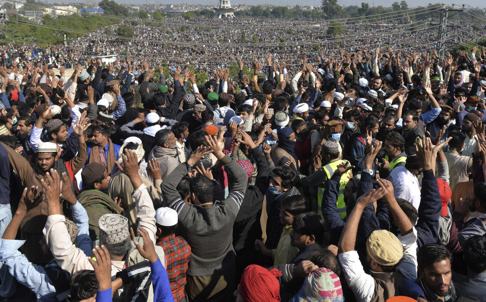 Mourners gather for the funeral prayer of Khadim Hussein Rizvi, an Islamist scholar and leader of Tehreek-e-Labiak Pakistan, in Lahore, Pakistan, Saturday, Nov. 21, 2020. Tens of thousands of mourners on Saturday thronged the funeral of the radical cleric whose Islamist party has defended Pakistan's controversial blasphemy law that calls for the death penalty for insulting Islam. (AP Photo/Waleed Ahmed)