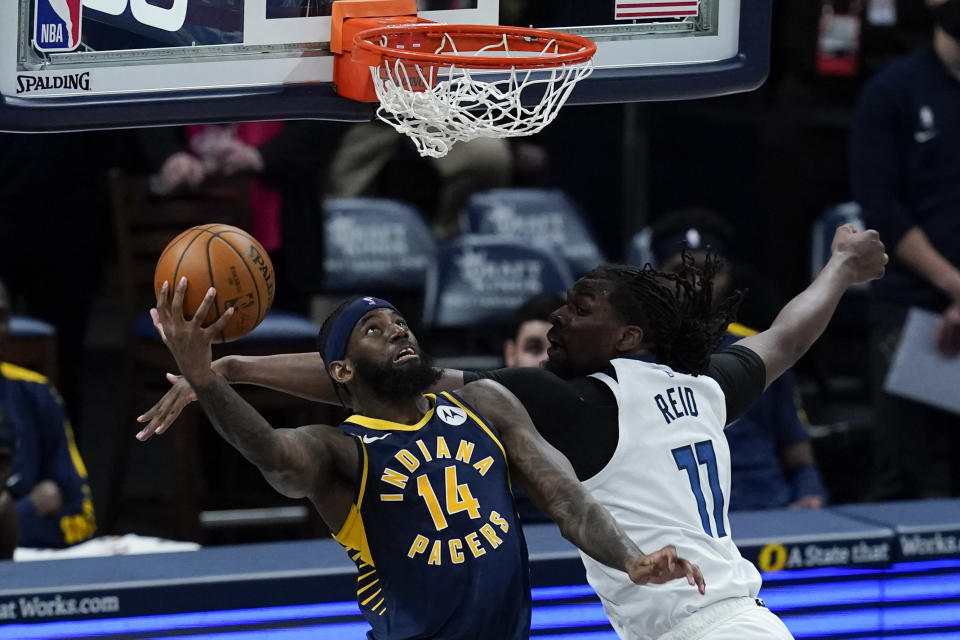 Indiana Pacers' JaKarr Sampson (14) goes up for a dunk against Minnesota Timberwolves' Naz Reid (11) during the first half of an NBA basketball game, Wednesday, April 7, 2021, in Indianapolis. (AP Photo/Darron Cummings)