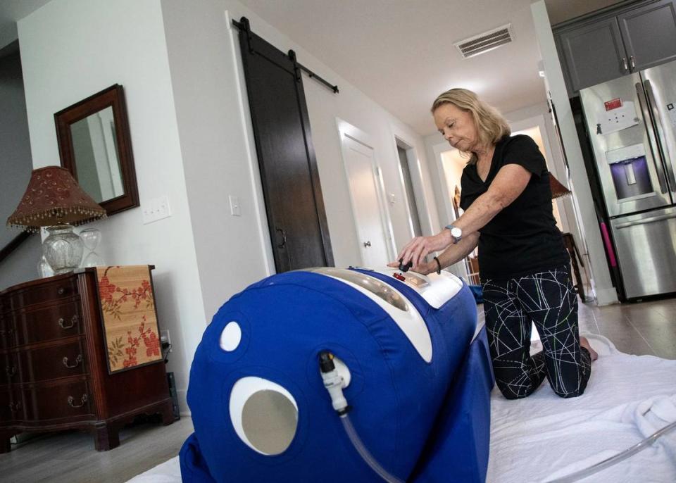 Cathy Gay adjusts the pressurization valve on a hyperbaric chamber at her Chapel Hill, N.C. home on Wednesday, August 17, 2022.