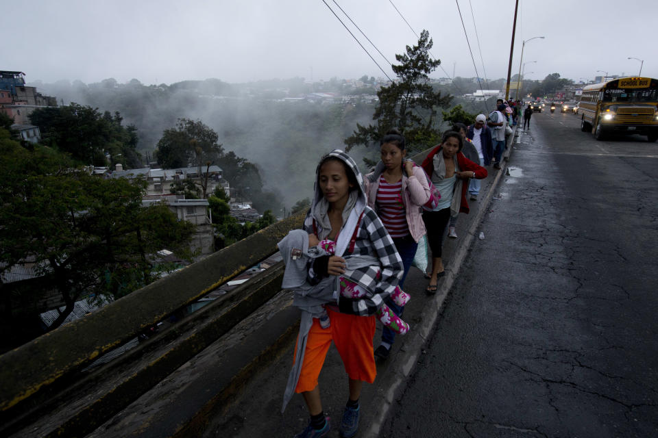 Migrantes hondureños salen de la Ciudad de Guatemala al amanecer del jueves 18 de octubre de 2018 mientras continúan su camino hacia Estados Unidos. (AP Foto/Moisés Castillo)