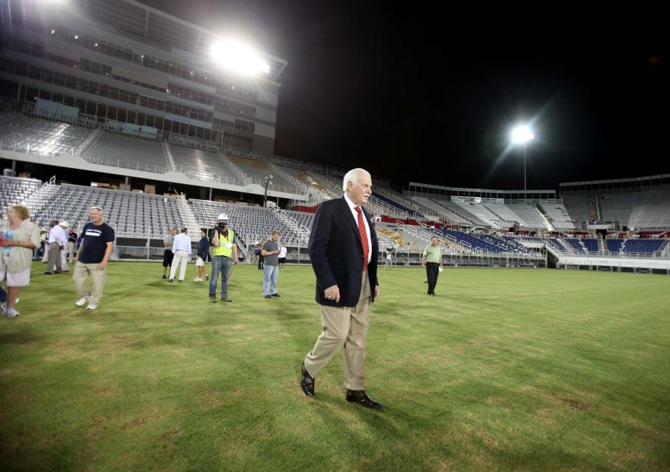 Then-FAU football coach Howard Schnellenberger walks onto the field at the school's new football stadium after flipping the switch to turn on the lights for the first time in August 2011. Post file photo