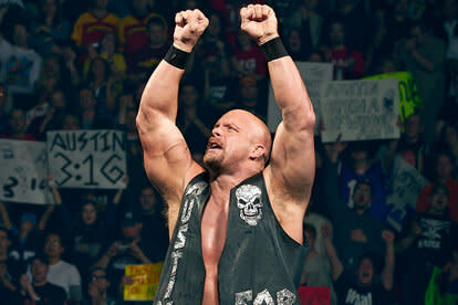 Stone Cold Steve Austin climbing the ropes of the ring with his fists up