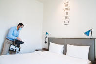 An employee wearing a mask due to the coronavirus pandemic fogs disinfectant in a hotel room at the Rove City Centre Hotel in Dubai, United Arab Emirates, Monday, July 6, 2020. Dubai reopened for tourists Tuesday amid the coronavirus pandemic, hoping to reinvigorate a vital industry for this city-state before its crucial winter tourist season. (AP Photo/Jon Gambrell)