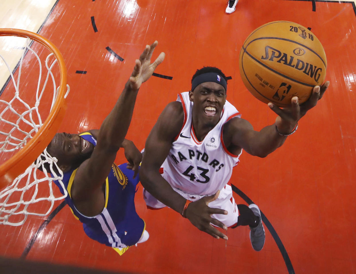 Kawhi Leonard, de los Raptors de Toronto, salta hacia la cesta frente a Andre Iguodala, de los Warriors de Golden State, durante el primer partido de la Final de la NBA, el jueves 30 de mayo de 2019 (Gregory Shamus/Pool Photo via AP)