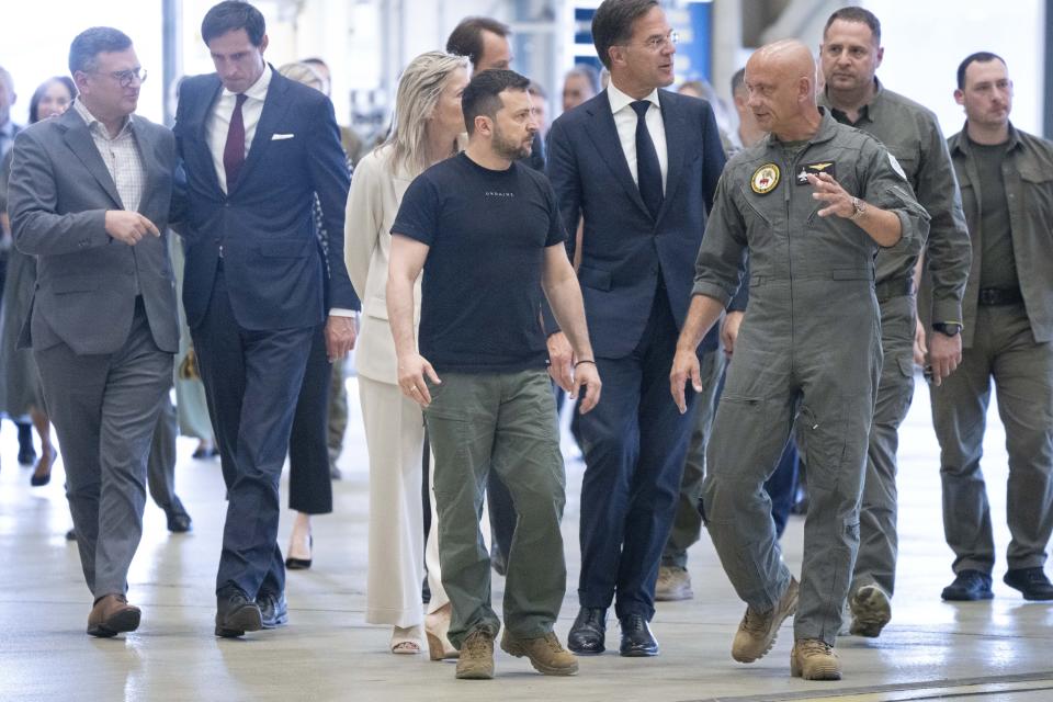 Ukrainian President Volodymyr Zelenskyy and Dutch caretaker Prime Minister Mark Rutte, listen to an F-16 fighter jet pilot in Eindhoven, Netherlands, Sunday, Aug. 20, 2023. Far left is Ukraine's Foreign Minister Dmytro Kuleba, walking with caretaker Dutch Foreign Minister Wobke Hoekstra. The leaders met at a military air base in the southern Dutch city, a day after Zelenskyy visited Sweden on his first foreign trip since attending a NATO summit in Lithuania last month. On Friday, the Netherlands and Denmark said that the United States had given its approval for the countries to deliver F-16s to Ukraine. (AP Photo/Peter Dejong)