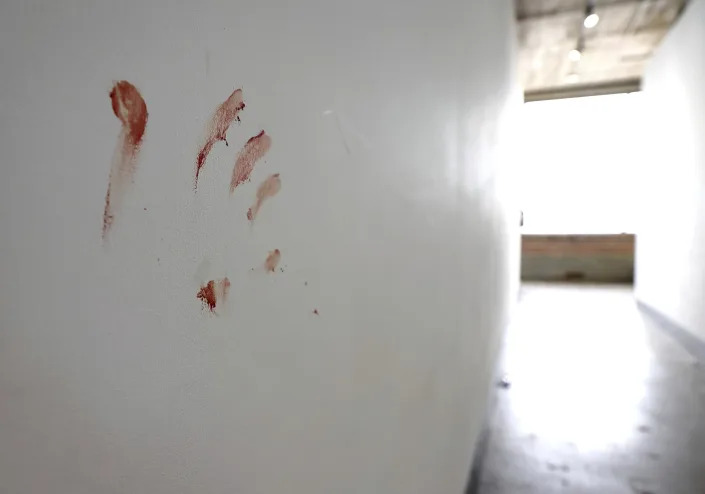 A bloody handprint can be seen on the wall of a hallway on the fifth floor of a building at 1409 Washington Ave., where 10 teens were shot overnight, one fatally, during a party in the building in downtown St. Louis, Sunday, June 18, 2023. (David Carson/St. Louis Post-Dispatch via AP)