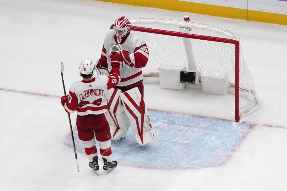 Detroit Red Wings goaltender Ville Husso, right, and Alex DeBrincat celebrate a 6-4 victory over the St. Louis Blues following an NHL hockey game Tuesday, Dec. 12, 2023, in St. Louis. (AP Photo/Jeff Roberson)