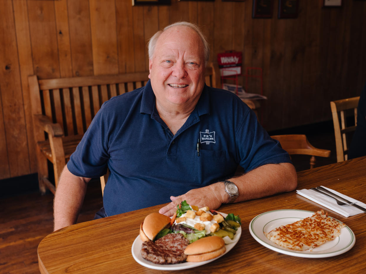 El propietario de Pie 'N Burger, Michael Osborn, con el platillo de hamburguesa de filete del restaurante, en Pasadena, California, el 3 de octubre de 2021. (Rozette Rago/The New York Times)