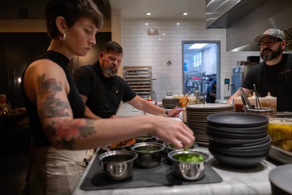 Canon co-owner Clay Nutting, center, preps with waitperson Katie Bradley and line cook Keith Franzen at Canon on Tuesday in East Sacramento. SB 478, also known as the Consumer Legal Remedies Act, eliminates surcharges and would apply to restaurants. It goes into effect July 1.