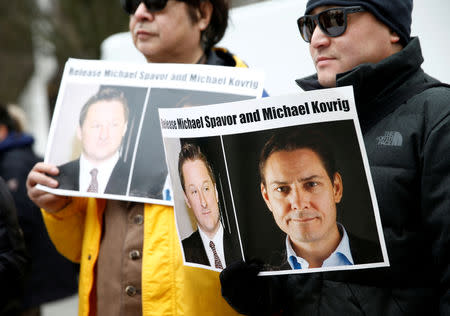 FILE PHOTO: FILE PHOTO: People hold signs calling for China to release Canadian detainees Michael Spavor and Michael Kovrig during an extradition hearing for Huawei Technologies Chief Financial Officer Meng Wanzhou at the B.C. Supreme Court in Vancouver, British Columbia, Canada, March 6, 2019. REUTERS/Lindsey Wasson/File Photo/File Photo