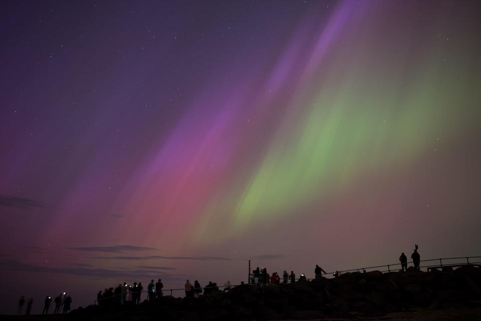 WHITLEY BAY, ENGLAND - MAY 10: People visit St Mary's lighthouse in Whitley Bay to see the aurora borealis, commonly known as the northern lights, on May 10, 2024 in Whitley Bay, England. The UK met office said a strong solar storm may allow northern parts of the UK the chance to see displays of aurora. (Photo by Ian Forsyth/Getty Images)