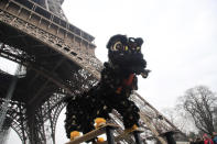 Members of the Chinese community dance with costumes to mark the Chinese New Year at the Eiffel Tower in Paris, Saturday Jan. 25, 2020. This year marks the "Year of the Rat" in the Chinese Lunar calendar. (AP Photo/Michel Euler)