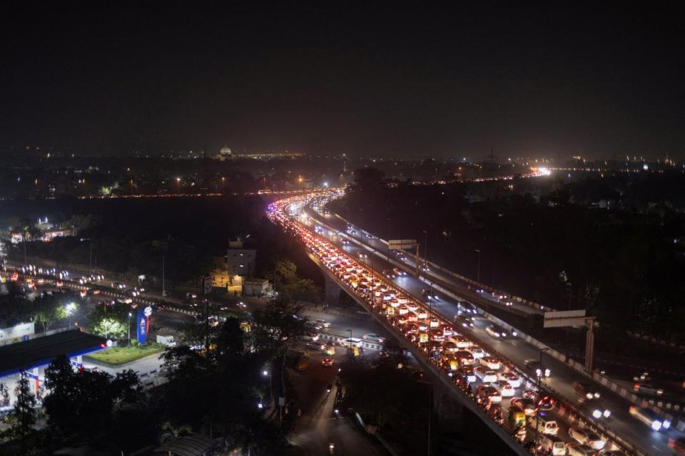 Traffic moves slowly amidst smog on a flyover in New Delhi on 29 November 2022 (REUTERS)