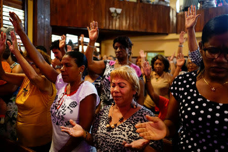 People react during a religious ceremony where victims of the Boeing 737 plane crash were remembered at a church in Havana, Cuba, May 20, 2018. REUTERS/Alexandre Meneghini