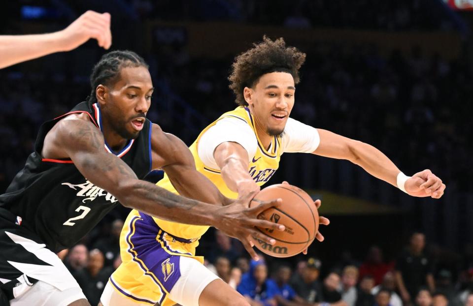 The Clippers' Kawhi Leonard, left, and Lakers' Jaxson Hayes battle for a loose ball