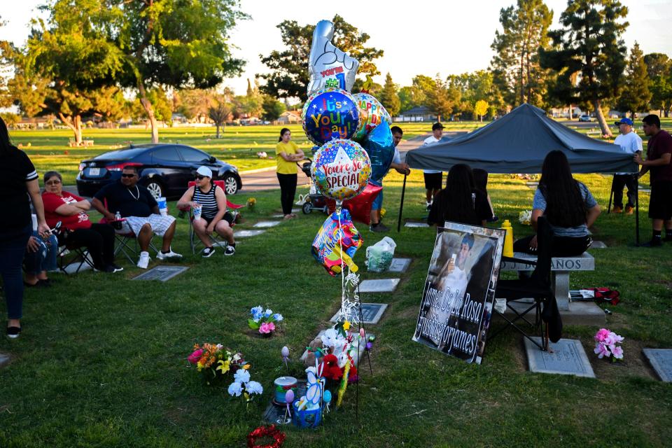 Leticia de la Rosa and her family spend the evening at Greenlawn Cemetery to celebrate the birthday of James de la Rosa. 