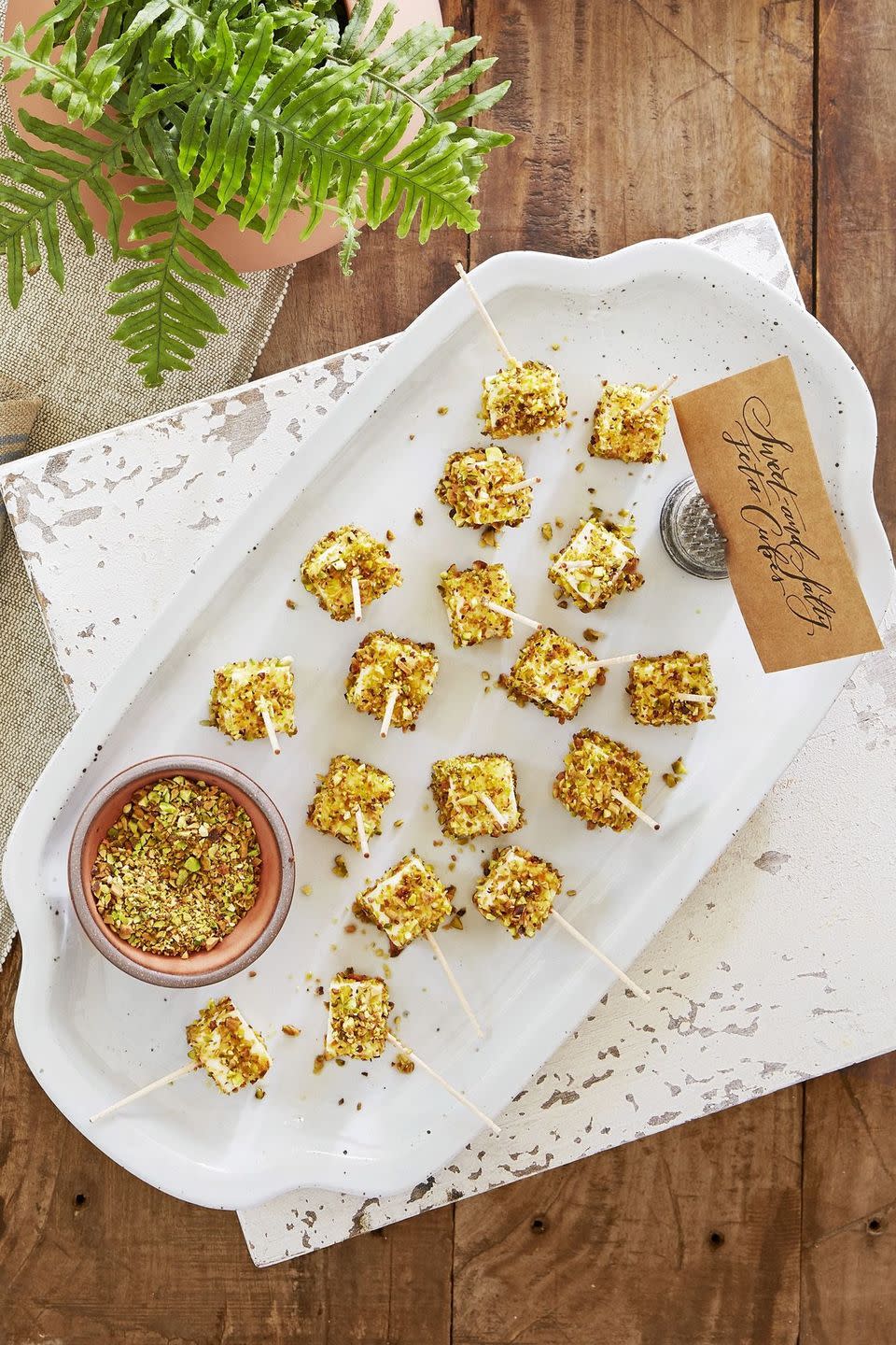 sweet and salty feta cubes on wooden picks and arranged on a white serving tray