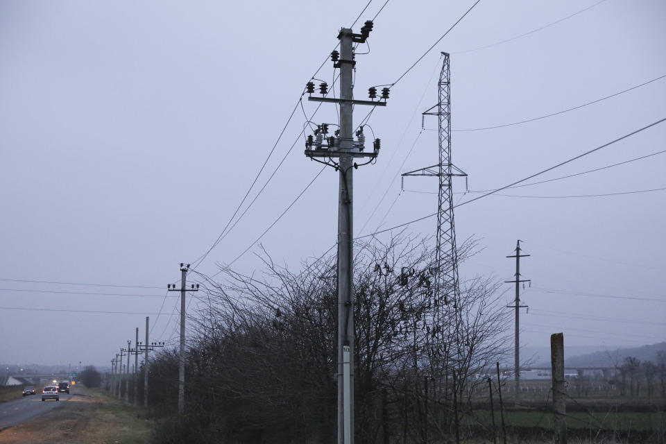 Cars drive by power lines on the outskirts of Chisinau, Moldova, on Nov. 16, 2022. Massive power blackouts that temporarily hit more than a half-dozen cities across Moldova this week following Russia's heavy bombardment of Ukraine have spotlighted the critical impact Moscow's war is having on energy security in Moldova, Ukraine's neighbor, which is already grappling with a series of acute crises. (AP Photo/Aurel Obreja)