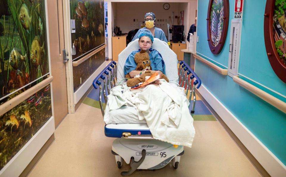 Amedy Dewey, 23, lays on a hospital bed as Lauren Zalewski, a certified registered nurse anesthetist, wheels her into the surgery room inside the University of Michigan C.S. Mott Children's Hospital in Ann Arbor on Monday, July 24, 2023.