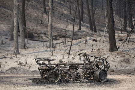 A burnt ATV lies on the road after the Carlton Complex Fire consumed an area near Malott, Washington July 20, 2014. REUTERS/David Ryder