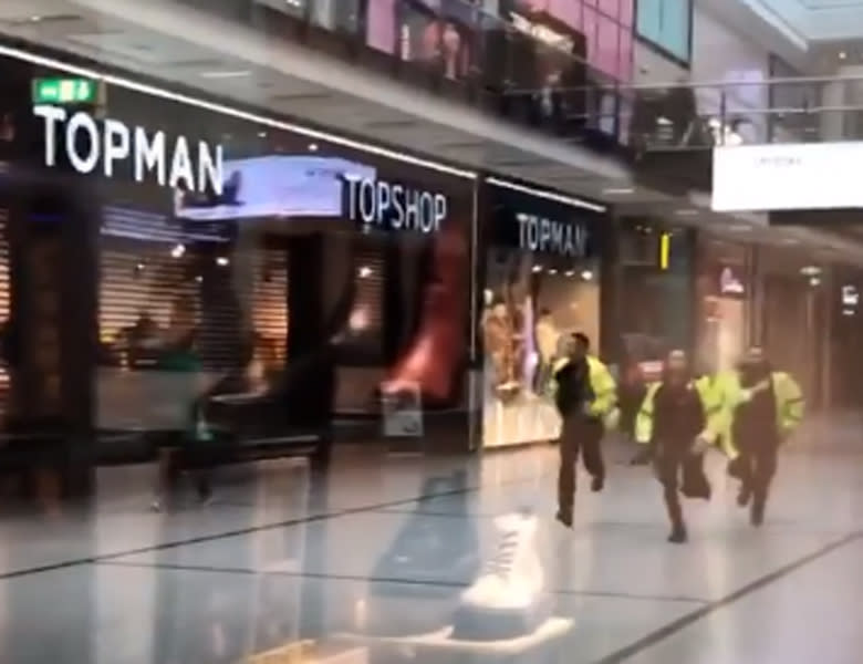 Handout videograb taken with permission from the twitter feed of @GrizzleMarine showing police running through the Arndale Centre in Manchester where at least four people have been treated after a stabbing incident.