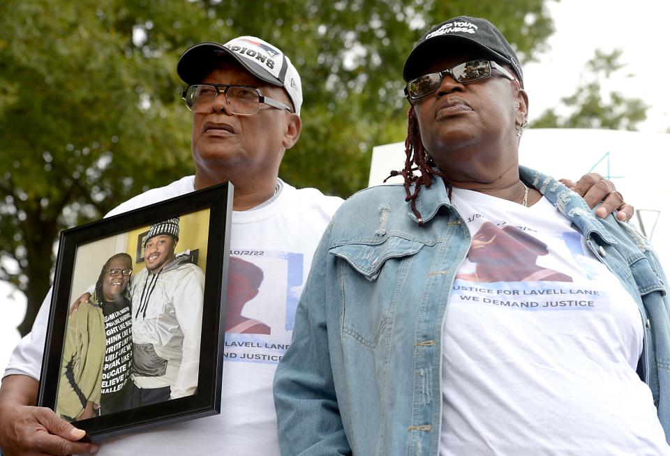 Lane's father, Andy Reese, and Lane's mother, Beverly Lane, with a picture of their son. 