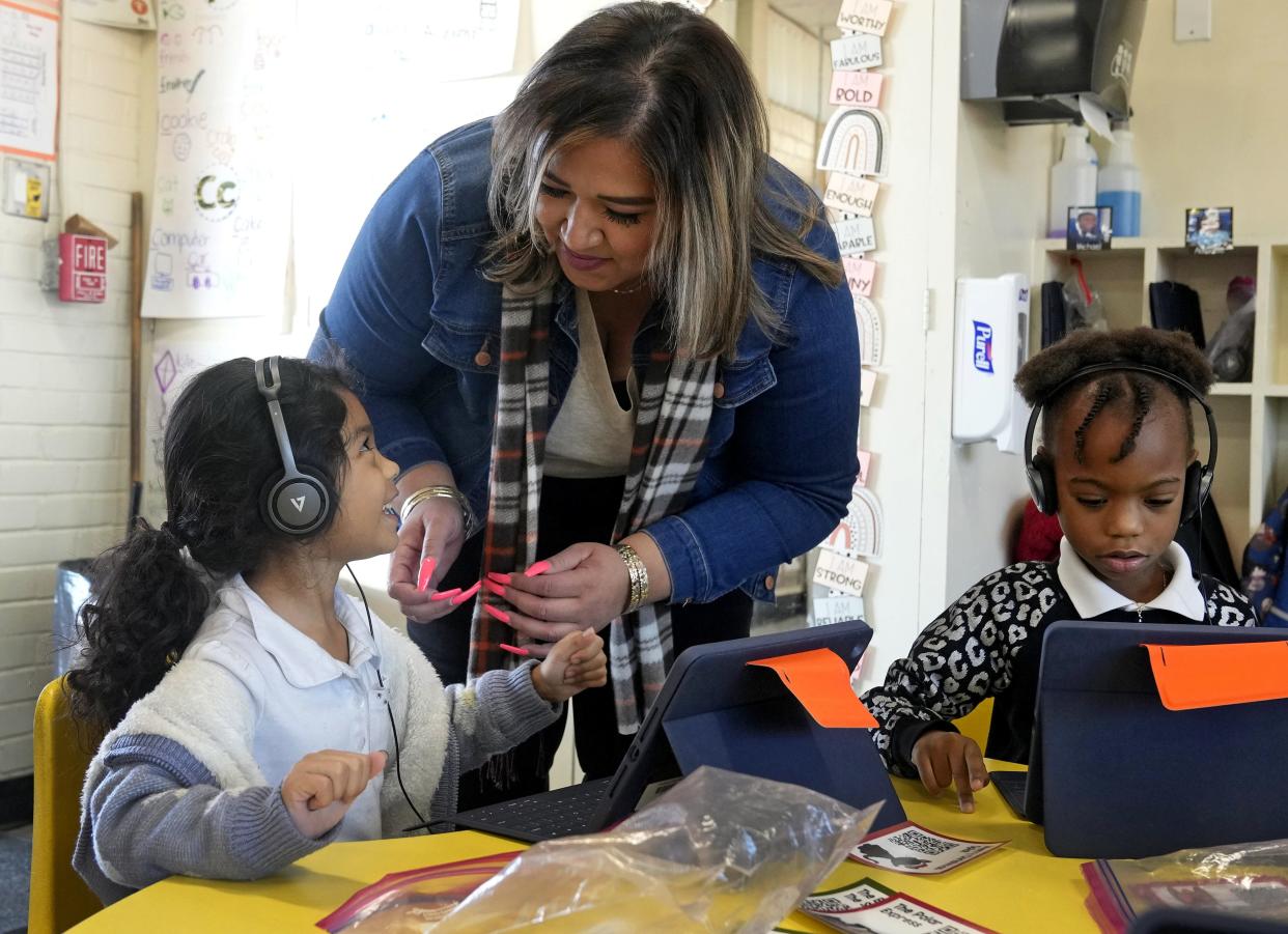 Naomi Prudencio Cruz gets a little assistance with her headphones from Jennifer Buchanan, a kindergarten teacher at Sunland STEAM Academy in the Roosevelt Elementary School District.