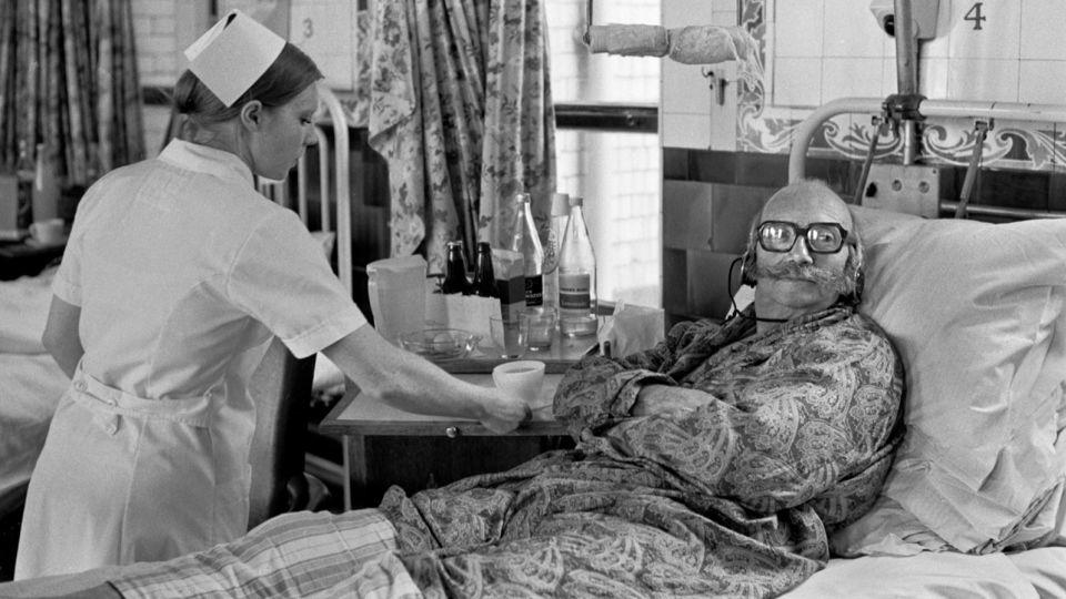 A patient at London's Charing Cross Hospital watches TV with headphones in 1972. - Homer Sykes/Alamy Stock Photo